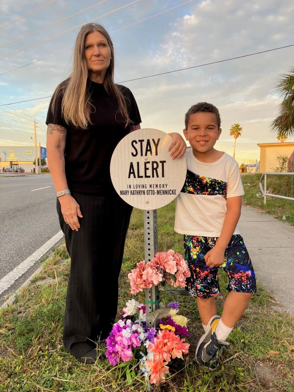 Roadway safety advocarte Miriam Moore and her grandson, Conner Kelso, 9, tend to the small roadside tribute to Moore's mother, Mary Otto-Mennicke, who was struck by a truck and killed on Dixon Boulevard near U.S. 1 in 2020.