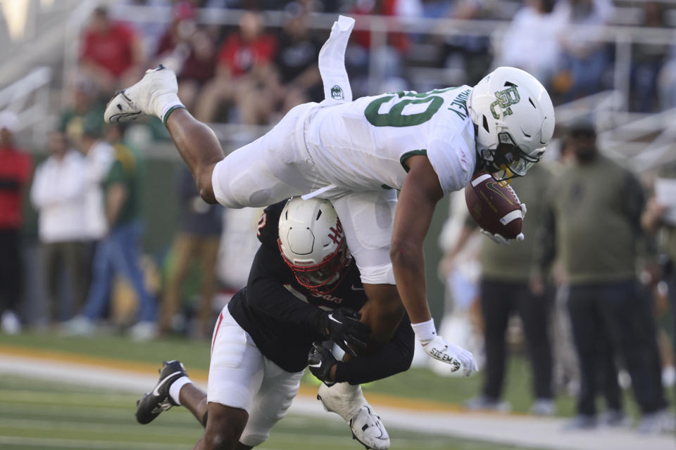 Baylor tight end Drake Dabney leaps over Houston defensive back Antonio Brooks for a short gain during the second half of an NCAA college football game, Saturday, Nov. 4, 2023, in Waco, Texas. (Rod Aydelotte/Waco Tribune-Herald via AP)