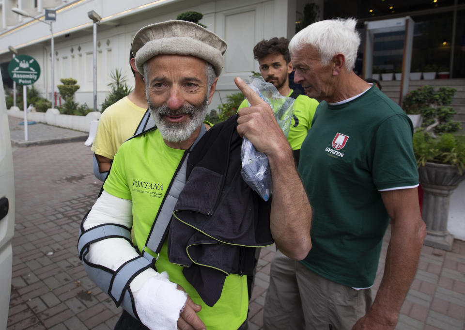 The team leader, Tarcisio Bellò, 57, points at a traditional Pakistani cap he wears while leaving fo Italian embassy in Islamabad, Pakistan, Thursday, June 20, 2019. The renowned Italian mountaineer, who narrowly survived along-with six other members of an expedition on a mountain, burst into tears Thursday when he recalled how helplessly he saw one of his Pakistani colleagues being swept away by an avalanche that struck them at an altitude of around 5,300 meters (17,390 feet) earlier this week. (AP Photo/B.K. Bangash)