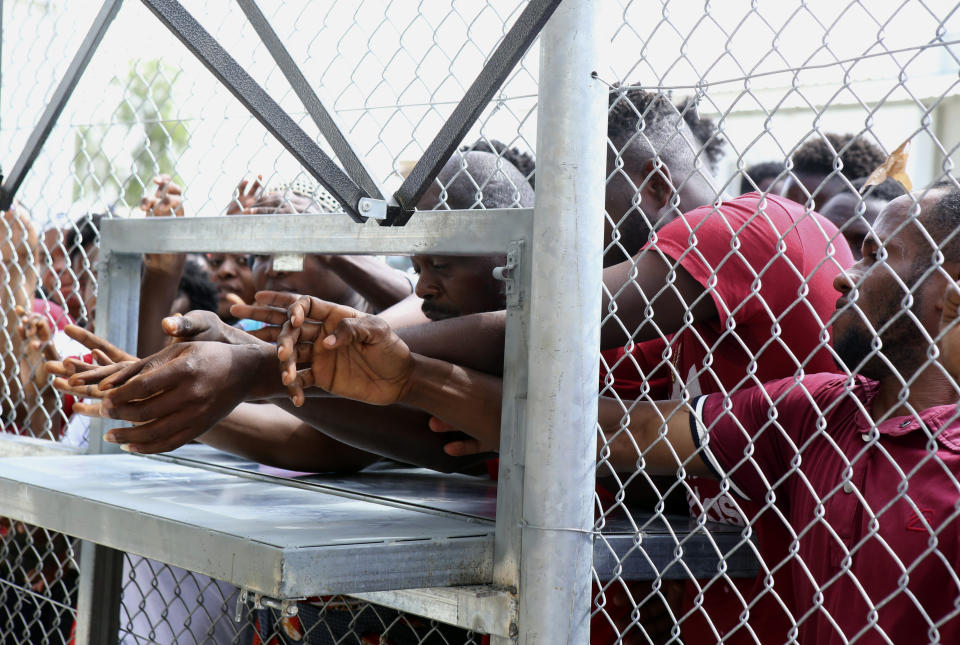 Migrants wait for food inside a refugee camp in Kokkinotrimithia outside of Nicosia, Cyprus, on Tuesday, June 23, 2020. Cyprus' interior minister says he has asked police to launch a criminal probe into allegations that underage girls staying at a migrants' reception center were sexually harassed by other adults staying there. (AP Photo/Philippos Christou)