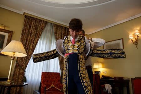 Alberto Lamelas is helped by his aide Angel Gomez to dress his bullfighter outfit in a hotel room before taking part in a bullfighting during San Isidro festival at Las Ventas bullring in Madrid, Spain, June 5, 2017. REUTERS/Sergio Perez