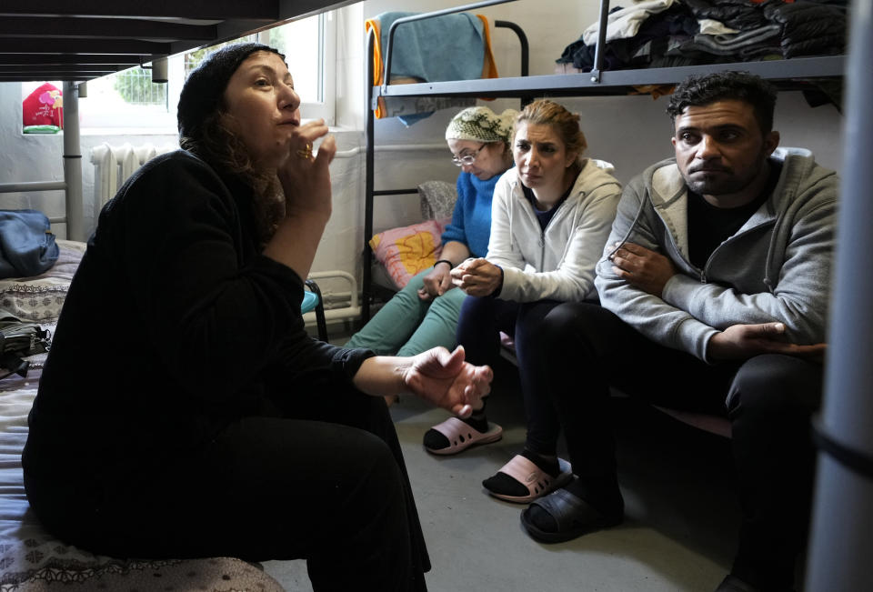 Boshra al-Moallem, second left, sits in a room with her two sisters and brother-in-law at a refugee center in Bialystok, Poland, on Wednesday, Sept. 29, 2021. After enduring a decade of war in Syria, Boshra al-Moallem and her two sisters seized their chance to flee, but the journey proved terrifying and nearly deadly. Al-Moallem, originally from Homs but who displaced to Damascus by the war, is one of thousands of people who have traveled to Belarus in recent weeks and then found herself helped to cross the border with the help of Belarusian guards, something the EU considers a form of “hybrid war” waged against the bloc with the use of human lives. (AP Photo/Czarek Sokolowski)