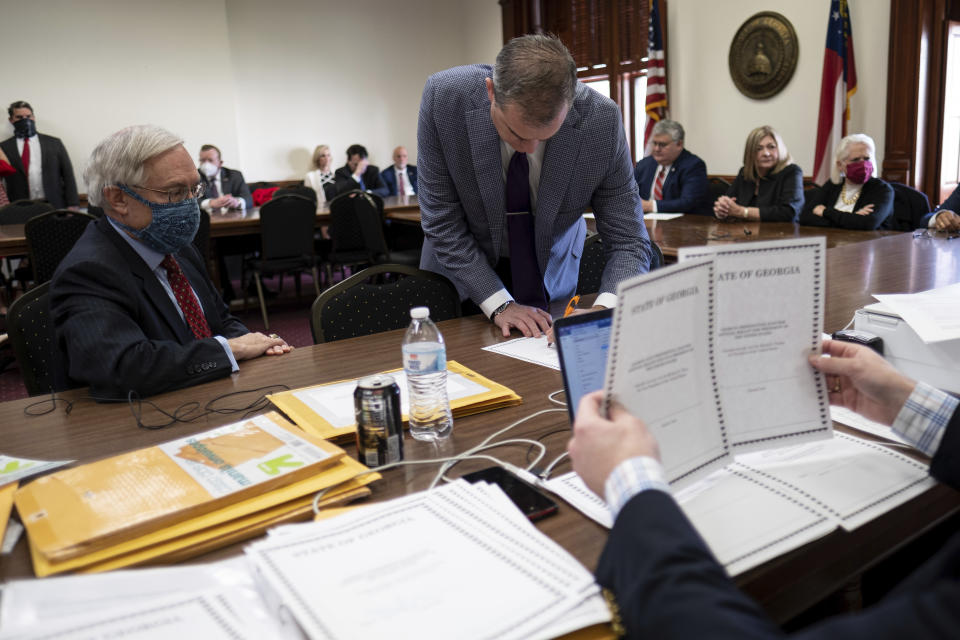 FILE - Shawn Still, now a Georgia Republican state senator, leans over to sign electoral certificates voting for Donald Trump and Vice President Mike Pence at the Georgia Capitol, Dec. 14, 2020, in Atlanta, during a meeting of Republican electors. The meeting of the electors has become a key element in the prosecution of Trump and 18 others in Georgia. Smith is one of the four people present that day who was indicted by a Fulton County grand jury in August 2023 on charges that he conspired to illegally overturn Democrat Joe Biden's win in Georgia. (AP Photo/Ben Gray, File)