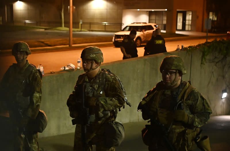 Members of the Wisconsin National Guard keep watch at their post behind the Kenosha Police Department building following the police shooting of Jacob Blake, a Black man, in Kenosha