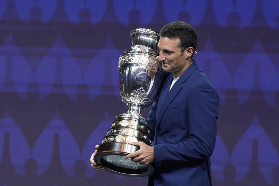 Argentina's soccer coach Lionel Scaloni carries the Copa America trophy during the draw ceremony for the Copa America soccer tournament, Thursday, Dec. 7, 2023, in Miami. The 16-nation tournament will be played in 14 U.S. cities starting with Argentina's opener in Atlanta on June 20, 2024. (AP Photo/Lynne Sladky)