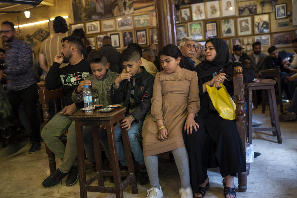 A family drinks tea at the Alshabander cafe on Al-Mutanabbi street in Baghdad, Iraq, Friday, Feb. 24, 2023. Iraq’s capital today is full of life and a sense of renewal, its residents enjoying a hopeful, peaceful interlude in a painful modern history. (AP Photo/Jerome Delay)