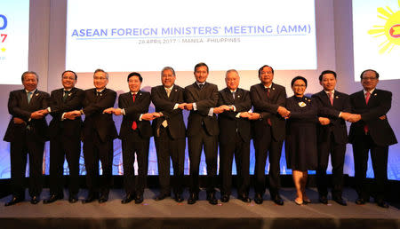Association of Southeast Asian Nations (ASEAN) Foreign Ministers, from left, Malaysia's Foreign Minister Anifah Aman, Myanmar U Kyaw Tin, Thai Foreign Minister Don Pramudwinai, Vietnam Foreign Minister Pham Binh Minh, Philippine Acting Foreign Affairs Secretary Enrique Manalo, Singapore's Foreign Minister Vivian Balakrishnan, Brunei Darussalam Foreign Minister Pehin Dato Lim Jock Seng, Cambodia's Foreign Minister Prak Sokhon, Laos Foreign Minister Saleumxay Kommasith, ASEAN Secretary General Le Luong Minh link arms as they pose for a family photo during the ASEAN Foreign Ministers Meeting (AMM) in Manila, Philippines, April 28, 2017. REUTERS/Aaron Favila/Pool
