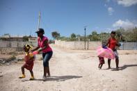 Schoolgirls walk along a street of Canaan, on the outskirts of Port-au-Prince