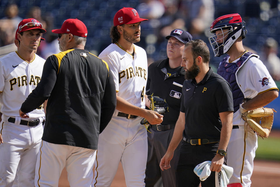 Pittsburgh Pirates starting pitcher Cody Ponce, center, walks off the mound after handing the ball to manager Derek Shelton, second from left, during the second inning of the team's baseball game against the Milwaukee Brewers in Pittsburgh, Saturday, July 3, 2021. (AP Photo/Gene J. Puskar)