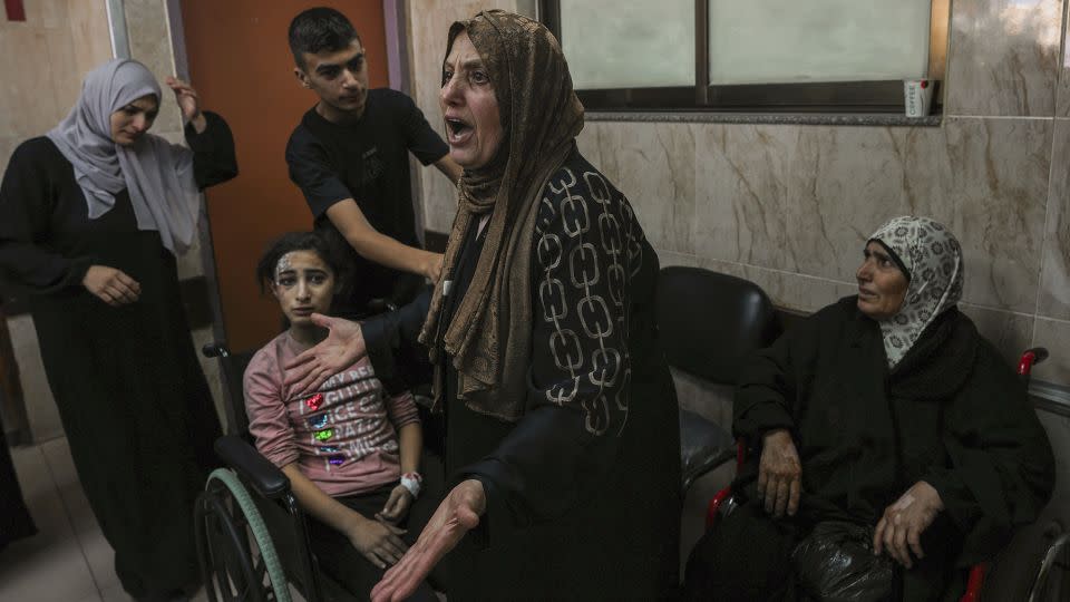 A Palestinian woman reacts to people wounded by Israeli airstrikes, at al-Aqsa hospital, in central Gaza, on October 15. Relief workers warn the bombardment is destroying the health care system. - Adel Hana/AP