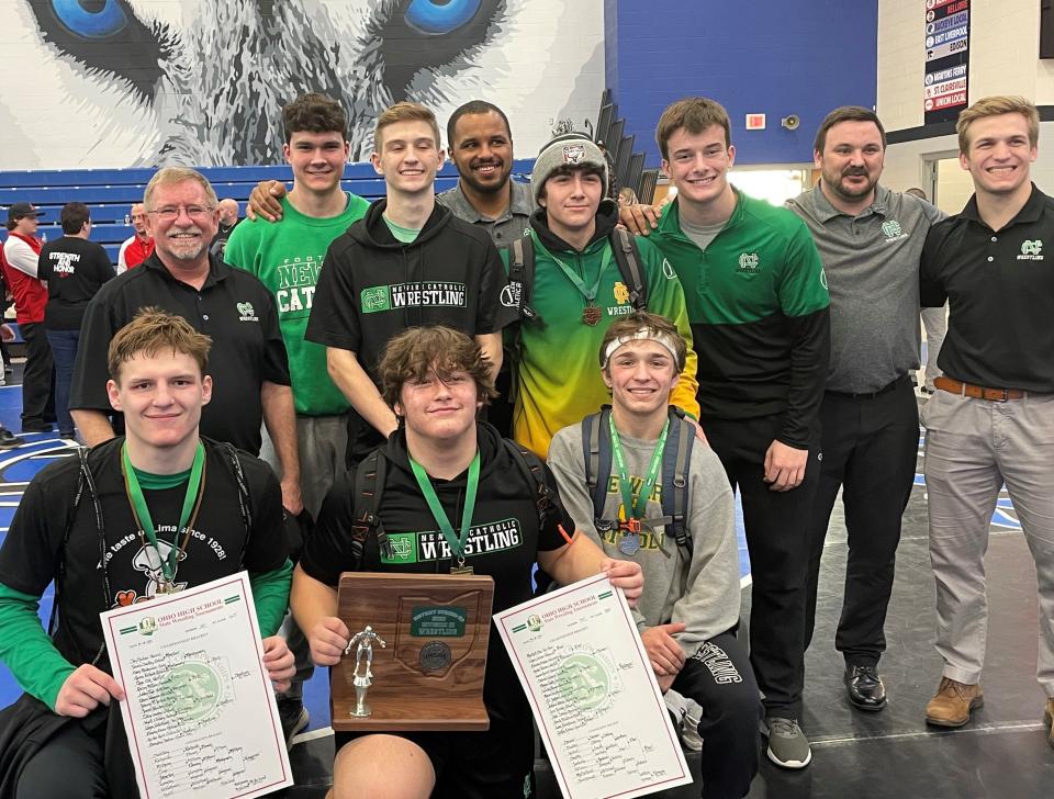 Newark Catholic heavyweight Griffin Halenar, who won the district title, is flanked by fellow state qualifiers Brendan Sheehan (165 champion) and Brian Luft (second at 132) as he holds the Green Wave's Division III district runnerup trophy Saturday at Harrison Central High School. Rugby Meza (150) took fifth and is a state alternate.