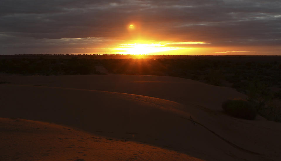 In this May 26, 2013 photo, the sun sets over the Perry Sand dunes in Wentworth, 1,043 kilometers (648 miles) from Sydney, Australia, during a seven-day, 3,000-kilometer (1,900-mile) journey across the Outback. (AP Photo/Rob Griffith)