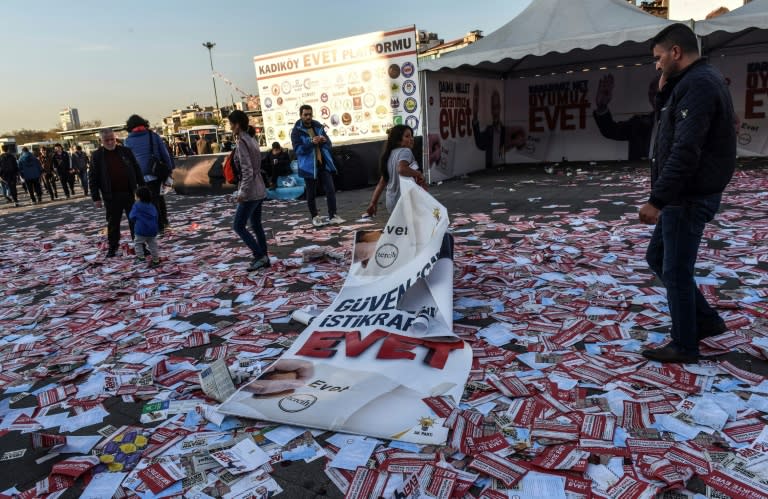 A girl drags a banner reading "yes" across piles of "yes" leaflets in the Kadikoy district of Istanbul