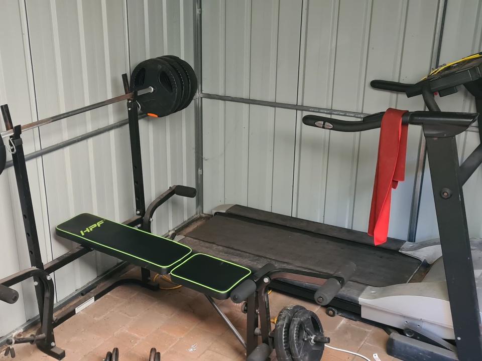 a home gym with weight lifting and treadmill