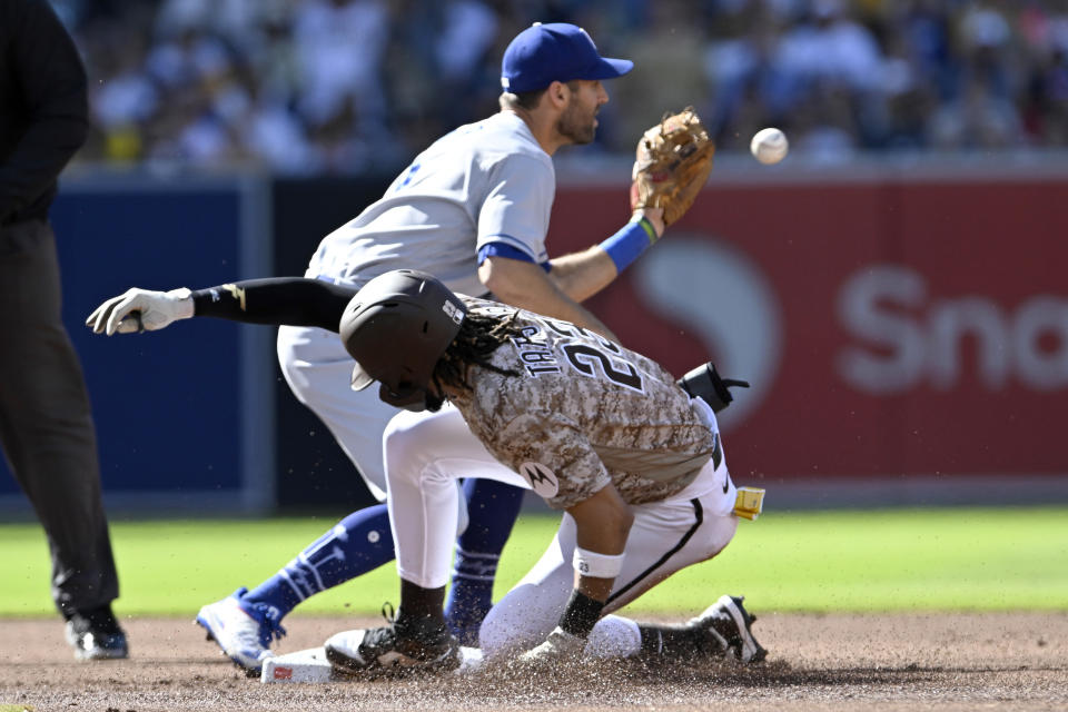 San Diego Padres' Fernando Tatis Jr., bottom, safely slides into second base for a double as Los Angeles Dodgers shortstop Chris Taylor, top, takes a late throw during the first inning of a baseball game in San Diego, Sunday, May 7, 2023. (AP Photo/Alex Gallardo)