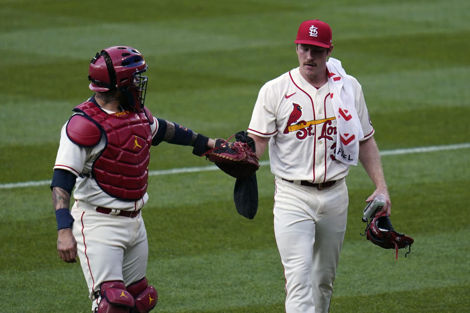 St. Louis Cardinals starting pitcher Miles Mikolas, right, gets a fist bump from catcher Yadier Molina as they head to the dugout before the start of a baseball game against the Chicago Cubs Saturday, May 22, 2021, in St. Louis. (AP Photo/Jeff Roberson)