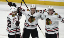 Chicago Blackhawks' Henrik Borgstrom, center, celebrates with Ryan Carpenter, left, and MacKenzie Entwistle after he scored a goal against the Minnesota Wild during the first period of an NHL hockey game, Saturday, Jan. 22, 2022, in St. Paul, Minn. (AP Photo/Jim Mone)