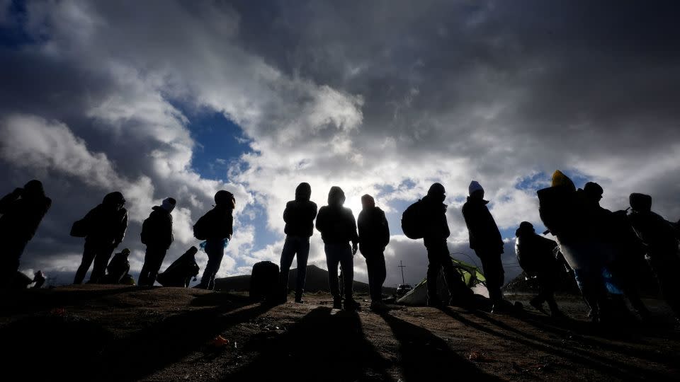 Asylum-seeking migrants wait to be processed in a makeshift campsite after crossing the border with Mexico on February 2, 2024, near Jacumba Hot Springs, California. - Gregory Bull/AP