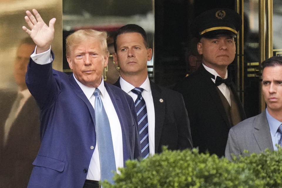 Former President Donald Trump, left, gestures as he leaves Trump Tower in New York, Thursday, April 13, 2023. Trump is expected to visit the offices of New York’s attorney general for his second deposition in a legal battle over his company’s business practices. (AP Photo/Seth Wenig)