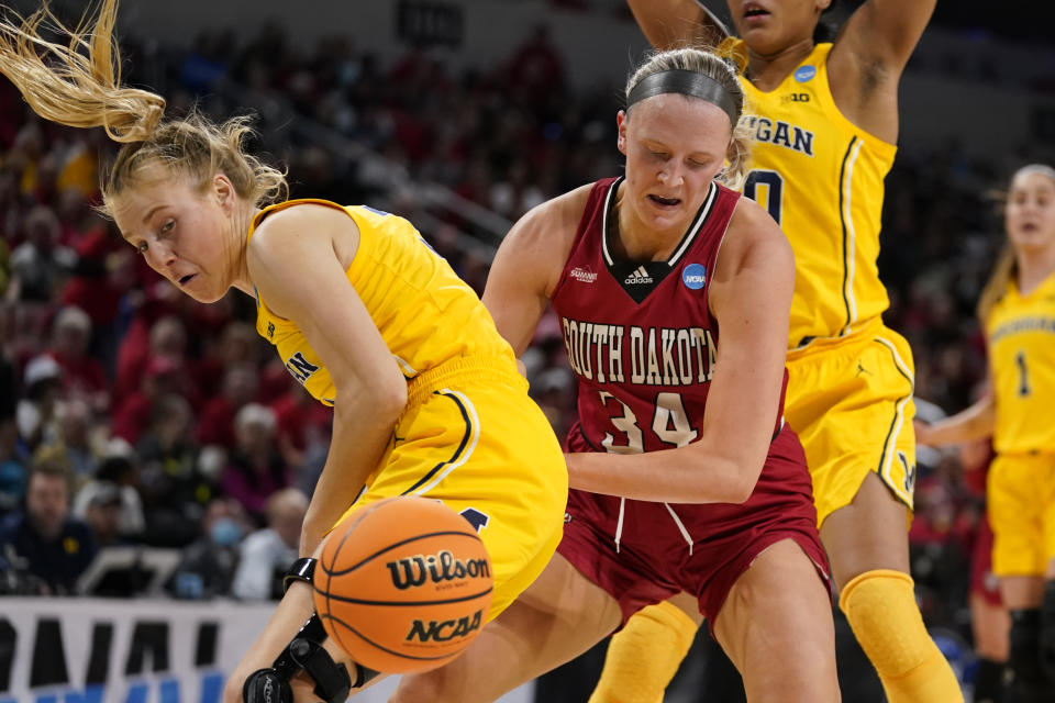 South Dakota's Hannah Sjerven (34) and Michigan's Maddie Nolan watch a loose ball during the first half of a college basketball game in the Sweet 16 round of the NCAA women's tournament Saturday, March 26, 2022, in Wichita, Kan. (AP Photo/Jeff Roberson)