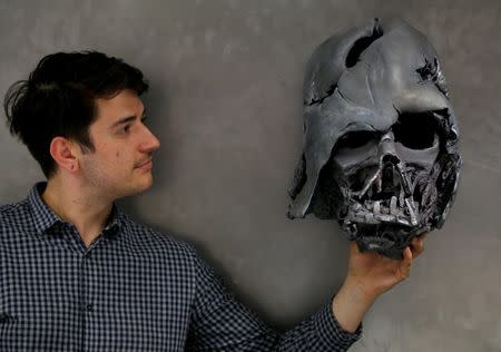 A worker holds a replica of Darth Vader's melted helmet from "Star Wars: The Force Awakens", in the Propshop headquarters at Pinewood Studios near London, Britain May 25, 2016. REUTERS/Peter Nicholls