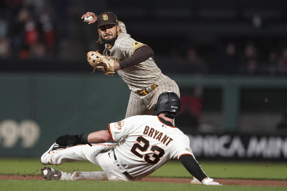 San Diego Padres shortstop Fernando Tatis Jr., top, throws to first base after forcing San Francisco Giants' Kris Bryant (23) out at second base during the fourth inning of a baseball game in San Francisco, Wednesday, Sept. 15, 2021. (AP Photo/Jeff Chiu)