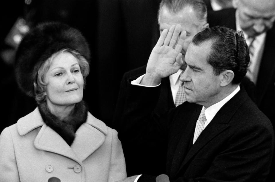 Richard Nixon holds his left hand on two family bibles and raises his right as he takes the oath as 37th President of the United States on the Capitol steps in Washington, D.C., Jan. 20, 1969. Pat Nixon holds the bibles.