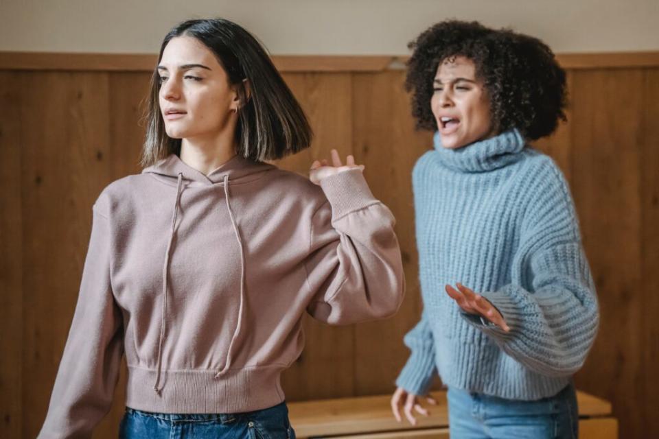 Annoyed woman waving off a Black woman who's trying to talk to her