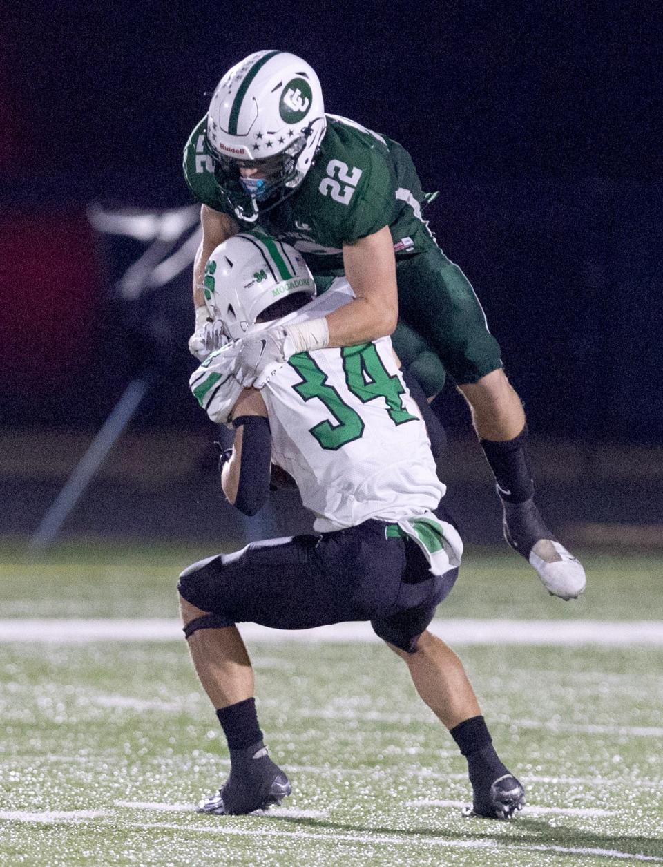 Central Catholic's Daniel Boron ,22, dives on Mogadore's Corey Lehner for a tackle in the second half at Central Catholic Friday September 29, 2023.