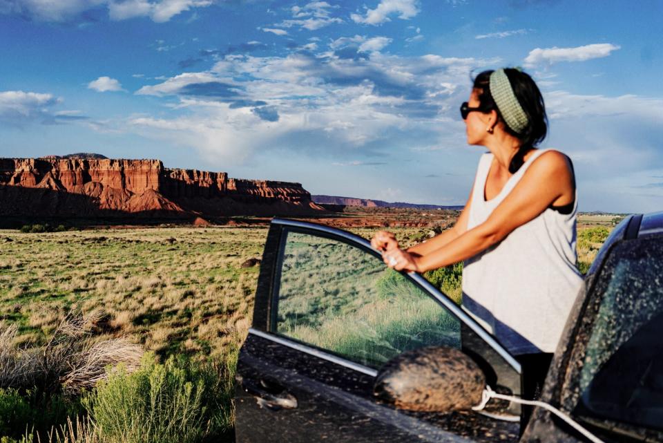 woman taking in desert landscape from car door