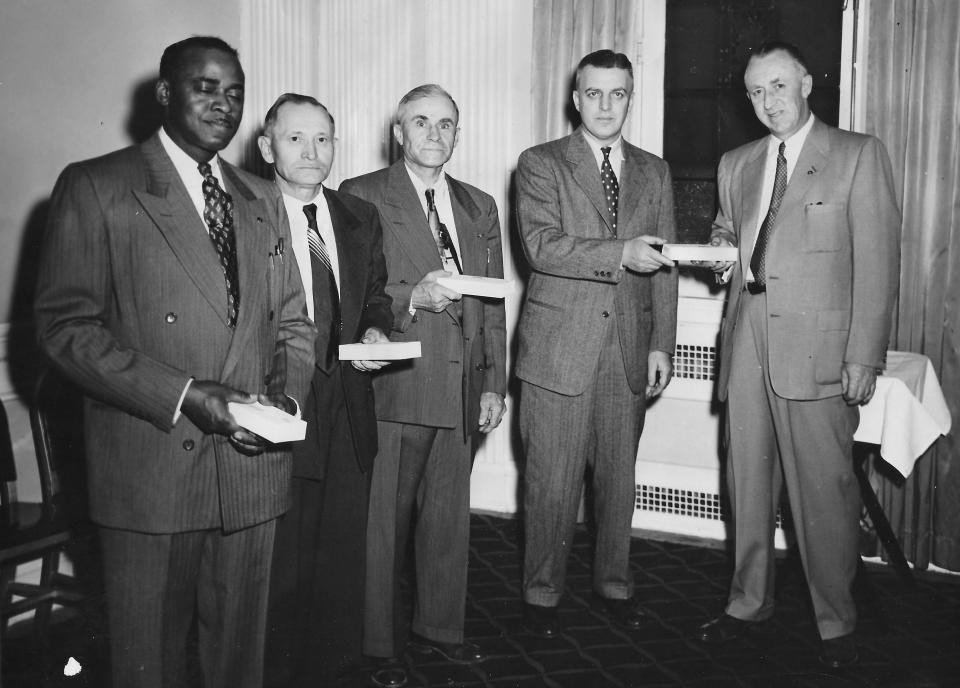 Atlantic Foundry workers William Solomon, Steve Kufchak, Raymond Evans and Leo Willenbacher receive gold watches from executive Charles Reymann Jr. in 1953 on their 25th anniversary with the Akron company.