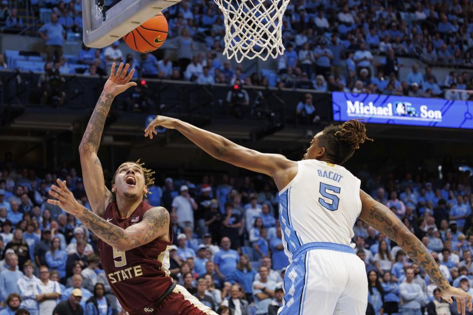 Florida State's De'Ante Green, left, attempts a shot as North Carolina's Armando Bacot, right, defends during the second half of an NCAA college basketball game in Chapel Hill, N.C., Saturday, Dec. 2, 2023. (AP Photo/Ben McKeown)