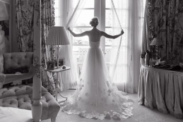 <p>Genevieve de Manio Photography</p> A bride posing by a window in a photo taken by Genevieve de Manio