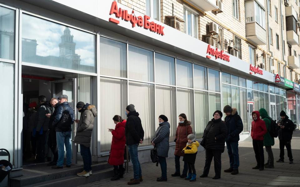 Citizens wait to withdraw cash from a branch of Alfa Bank in Moscow on Sunday - AP Photo/Victor Berzkin