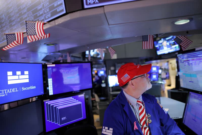 FILE PHOTO: A trader works on the trading floor at the New York Stock Exchange (NYSE) in Manhattan, New York City