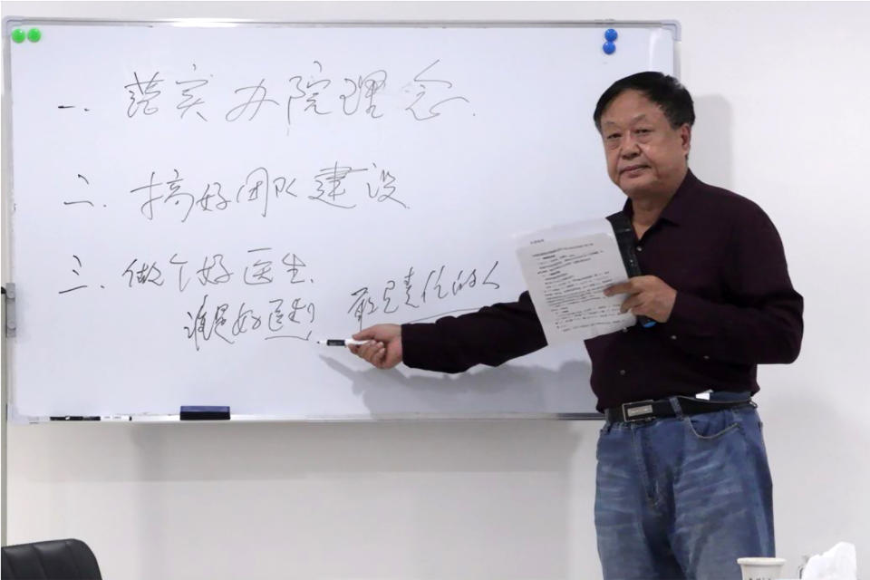 In this Oct. 5, 2020, photo provided by the Legal Team of Dawu Group, Sun Dawu stands at a whiteboard at a hospital in Baoding in northern China's Hebei Province. A prominent Chinese pig farmer who was detained after praising lawyers during a crackdown on legal activists by President Xi Jinping's government has been sentenced to 18 years in prison on charges of organizing an attack on officials and other offenses. The board reads "implement the concept of running the hospital, do a good job in team building, be a good doctor who is a good doctor, a responsible person." (Legal Team of Dawu Group via AP)