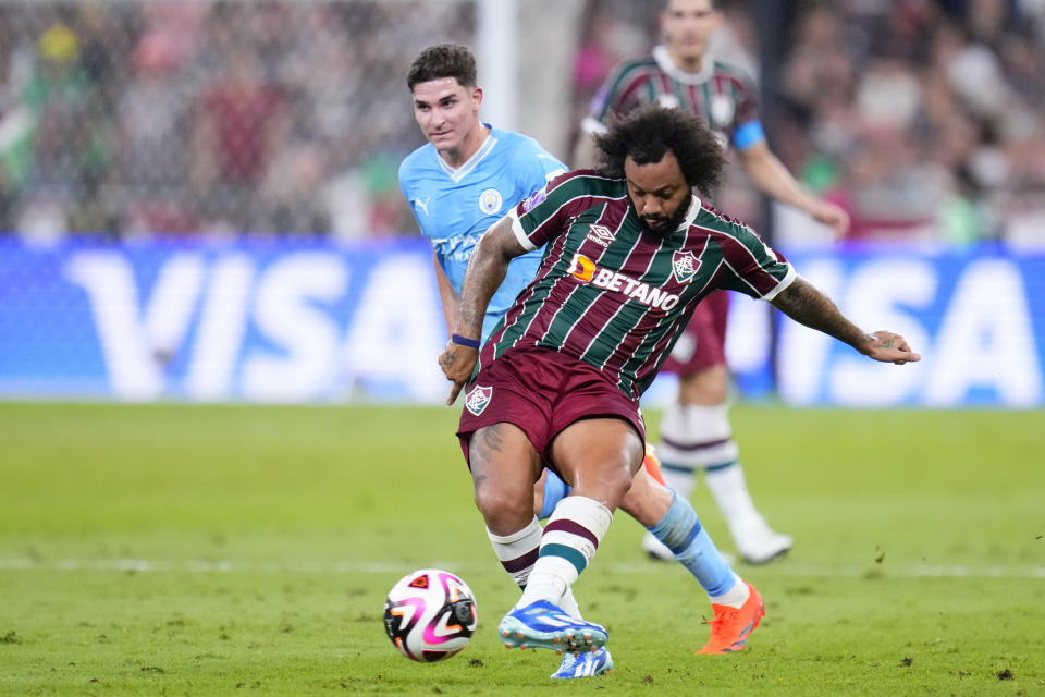 Fluminense's Marcelo passes the ball in front of Manchester City's Julian Alvarez, background left, during the Soccer Club World Cup final match between Manchester City FC and Fluminense FC at King Abdullah Sports City Stadium in Jeddah, Saudi Arabia, Friday, Dec. 22, 2023. (AP Photo/Manu Fernandez)