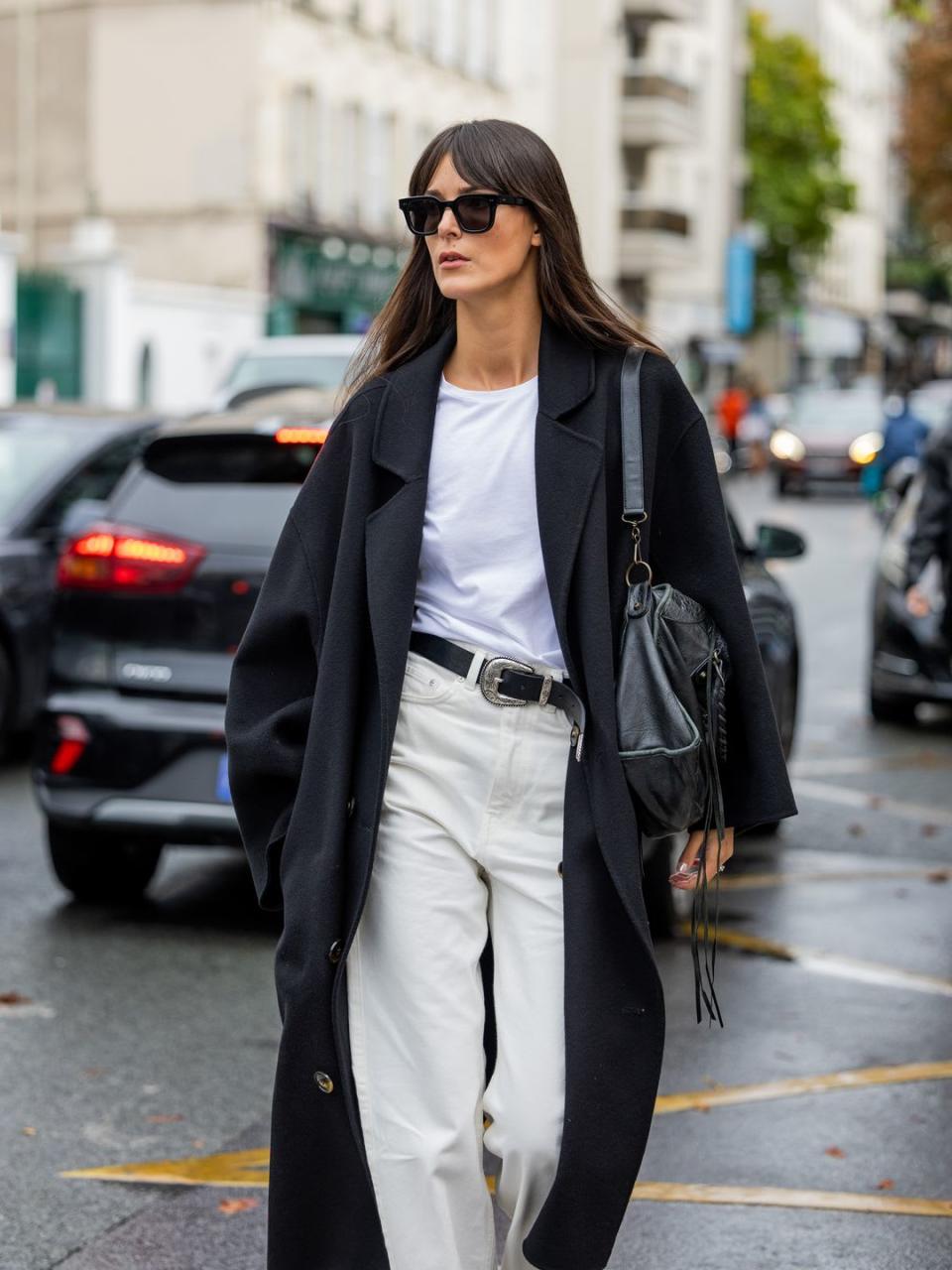  Leia Sfez styles white jeans with a classic white tee and a Western-style belt 