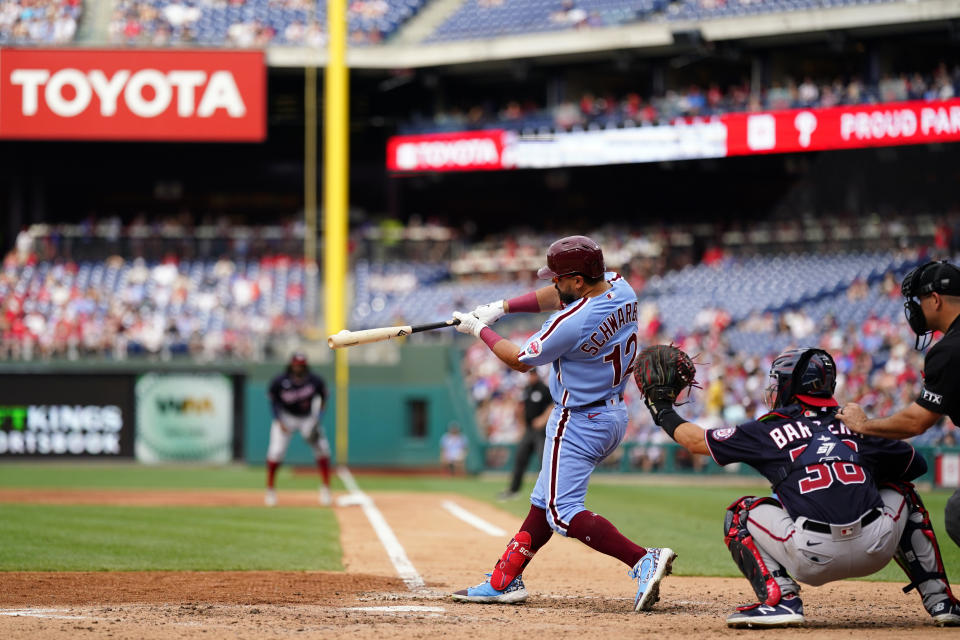 Philadelphia Phillies' Kyle Schwarber hits a run-scoring ground out against Washington Nationals pitcher Joan Adon during the fourth inning of a baseball game, Thursday, July 7, 2022, in Philadelphia. (AP Photo/Matt Slocum)
