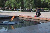 Russian President lays a bunch of flowers at the eternal flame in memory of those killed during WWII as he takes part in a wreath laying ceremony at the Tomb of Unknown Soldier in Moscow, Russia, Tuesday, June 22, 2021, marking the 80th anniversary of the Nazi invasion of the Soviet Union. (Alexei Nikolsky, Sputnik, Kremlin Pool Photo via AP)