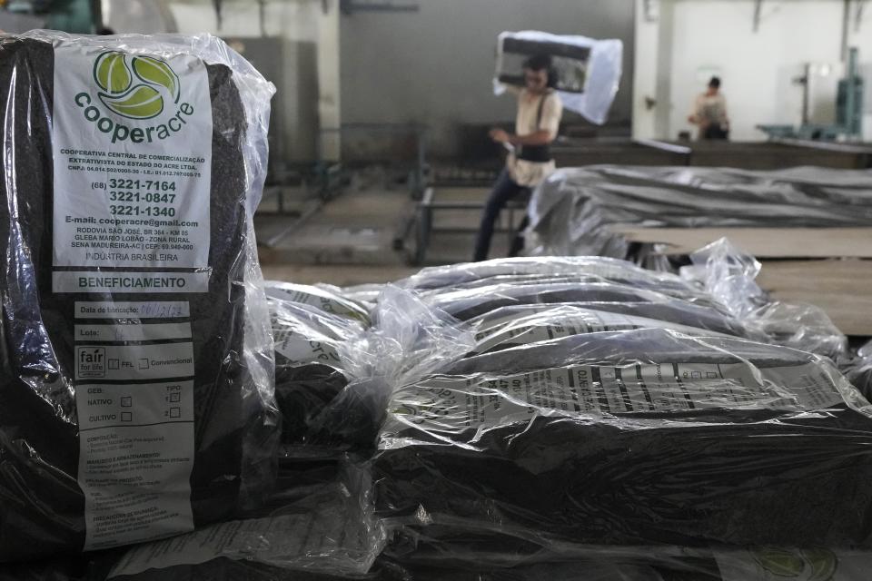 A worker sorts processed and packaged rubber at a rubber industrial plant of the cooperative called Cooperacre, in Sena Madureira, Acre state, Brazil, Friday, Dec. 9, 2022. The shoe manufacturer Veja works with Cooperacre, reenergizing the production of a sustainable forest product and improving the living of hundreds of rubber tapper families. (AP Photo/Eraldo Peres)