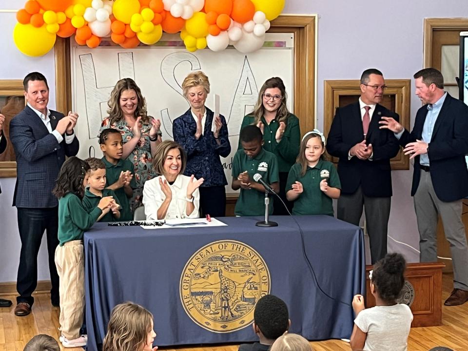 Iowa Gov. Kim Reynolds claps after signing a law directing more funding to charter schools on Friday, May 17, 2024 at the Horizon Science Academy in Des Moines.
