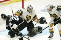 Los Angeles Kings left wing Andreas Athanasiou, left, tries to get a shot past Vegas Golden Knights goaltender Robin Lehner, center, as defenseman Zach Whitecloud defends during the first period of an NHL hockey game Monday, April 12, 2021, in Los Angeles. (AP Photo/Mark J. Terrill)