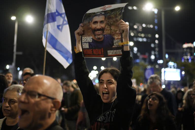 Familiares de rehenes israelíes retenidos por Hamas en Gaza sostienen sus fotografías y gritan consignas en una manifestación pidiendo su regreso, en Tel Aviv, Israel, el sábado 16 de diciembre de 2023. 