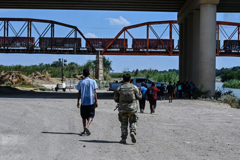 Migrants are apprehended by US Border Patrol and National Guard troops in Eagle Pass, Texas, near the border with Mexico on June 30, 2022. / Credit: CHANDAN KHANNA/AFP via Getty Images