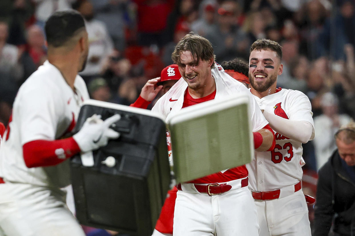 St. Louis Cardinals' Nolan Gorman, center, is mobbed by teammates as they celebrate after his walkoff home run during the ninth inning of a baseball game against the Arizona Diamondback,s Monday, April 22, 2024, in St. Louis. (AP Photo/Scott Kane)
