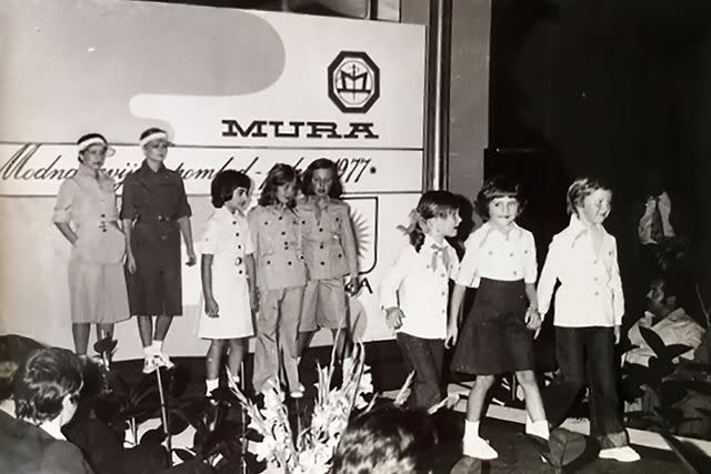 <p>STR/AFP via Getty </p> A young Melania Trump (second from right) at a 1977 fashion show at the Slovenian textile factory where her mother worked for 33 years