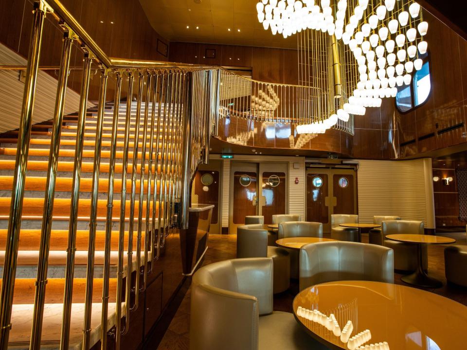 a dining room with a chandelier and staircase