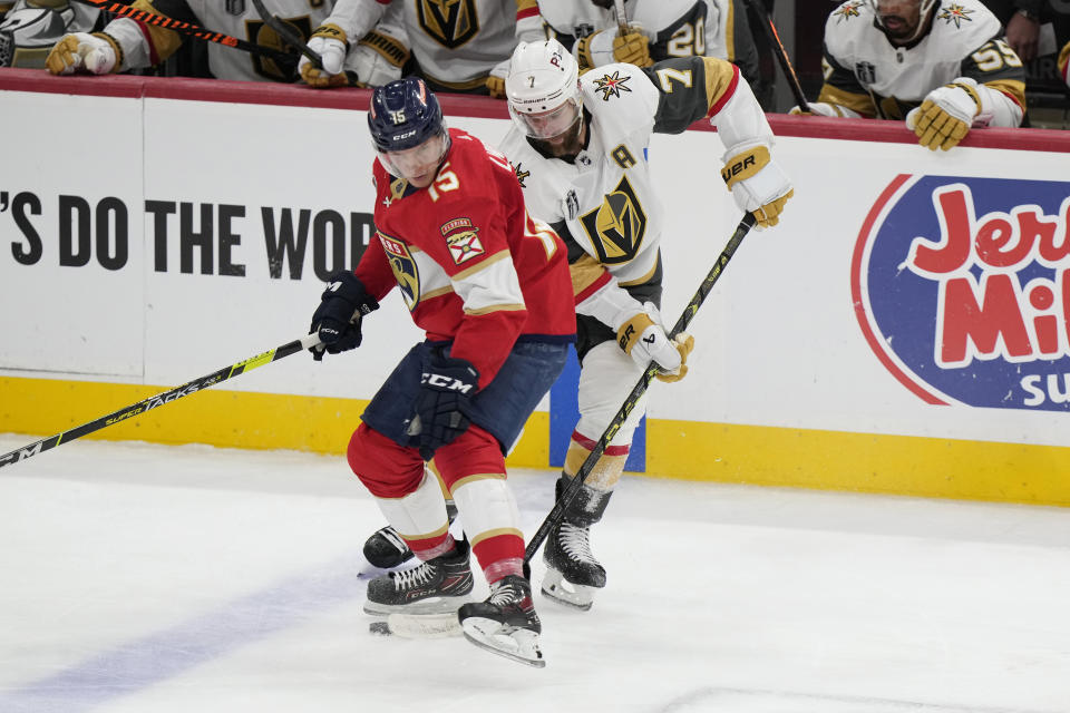 Florida Panthers center Anton Lundell (15) and Vegas Golden Knights defenseman Alex Pietrangelo (7) go after the puck during the second period in Game 4 of the NHL hockey Stanley Cup Finals, Saturday, June 10, 2023, in Sunrise, Fla. (AP Photo/Wilfredo Lee)