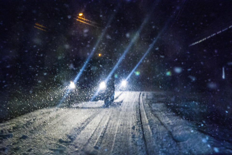 Car driving during winter snowstorm.